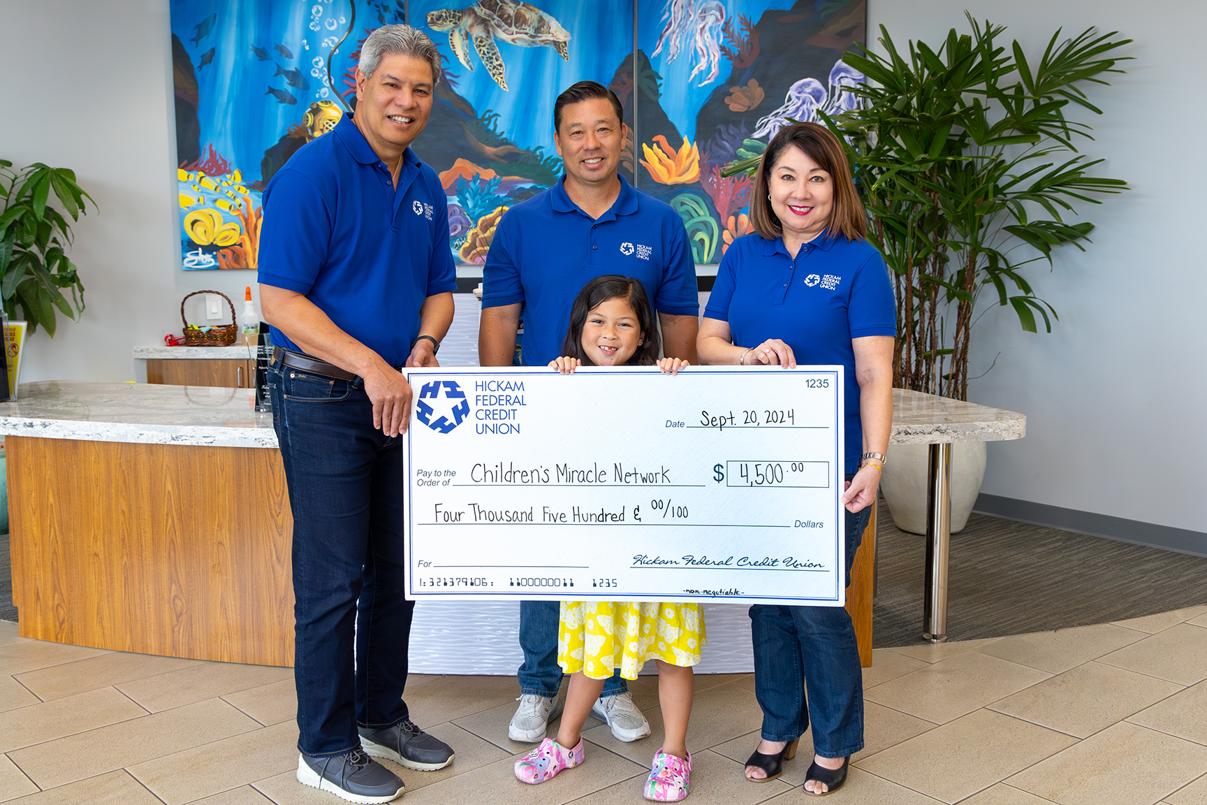 Children's Miracle Network Champion and HFCU Senior Management Holding a Giant Check